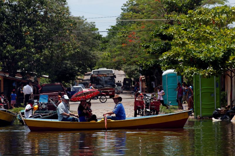 Moradores andam de barco em área alagada de Assunção nesta quinta-feira (24) (Foto: Norberto Duarte/AFP)