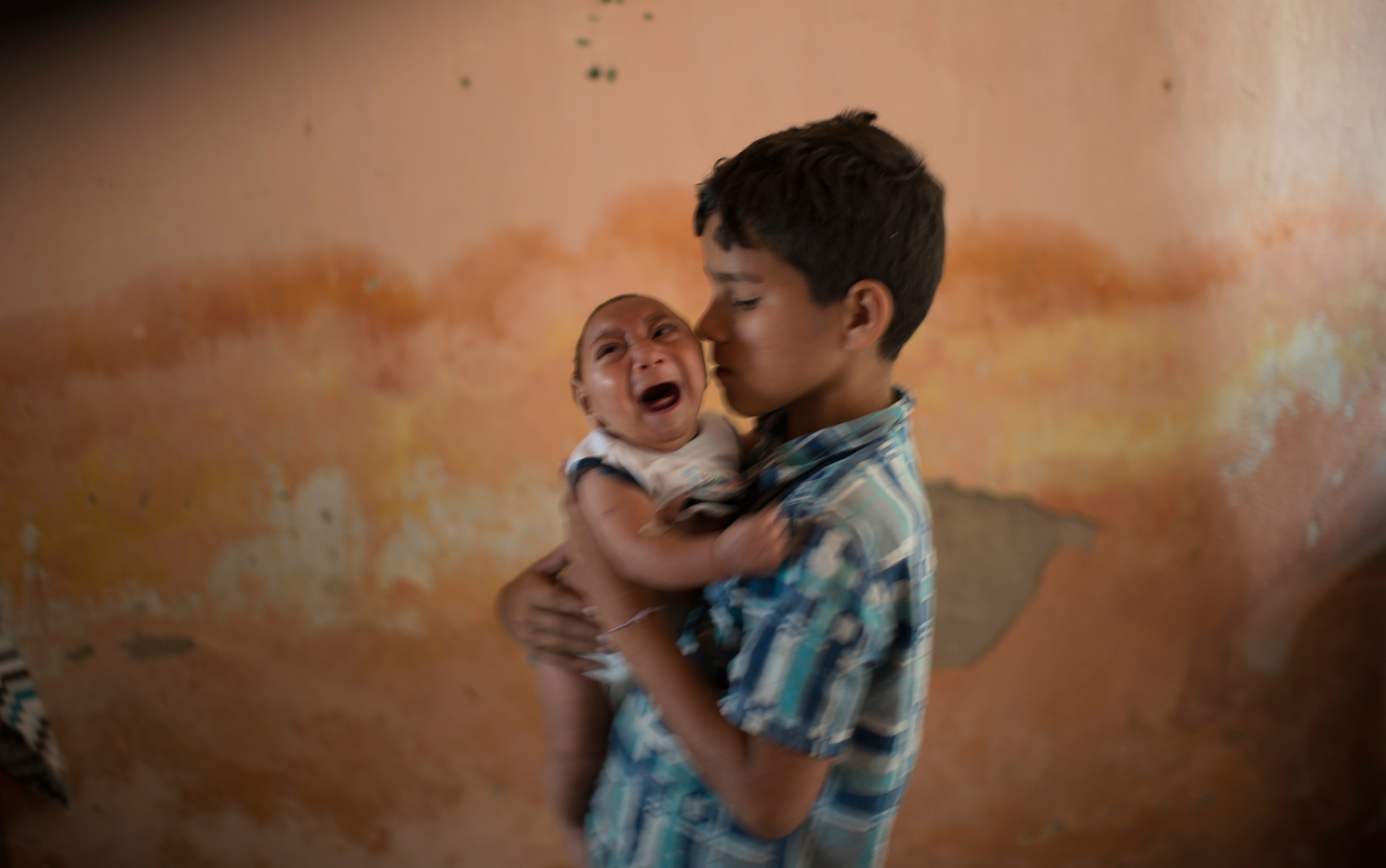 Foto de 23 de dezembro mostra menino Elison, de 10 anos, cuidando de seu irmão de 2 meses José Wesley, que nasceu com microcefalia, em Poço Fundo, no Pernambuco (Foto: AP Photo/Felipe Dana)