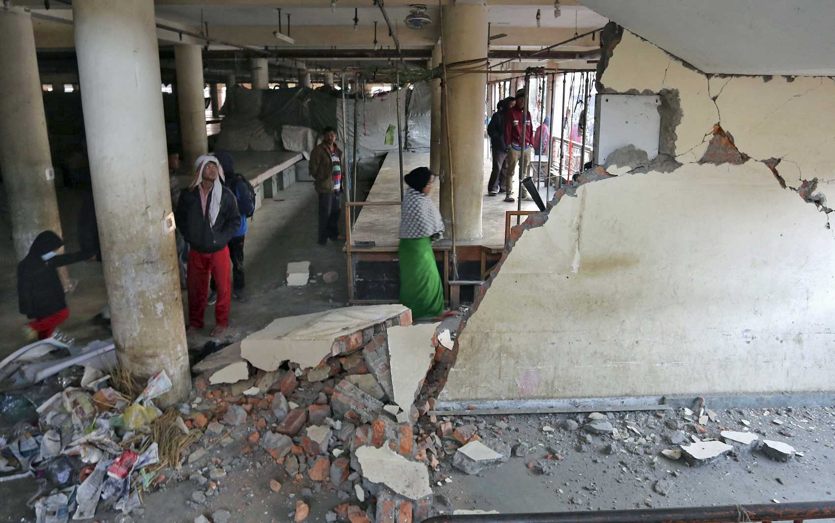 Pessoas em um edifício danificado em Imphal (Foto: Reuters)