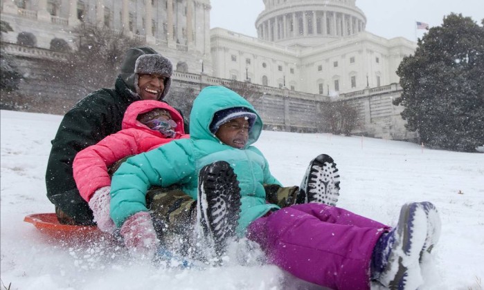Bashon Mann e seus filhos brincam na neve em frente ao capitólio, em Washington (Foto: J. Scott Applewhite / AP)
