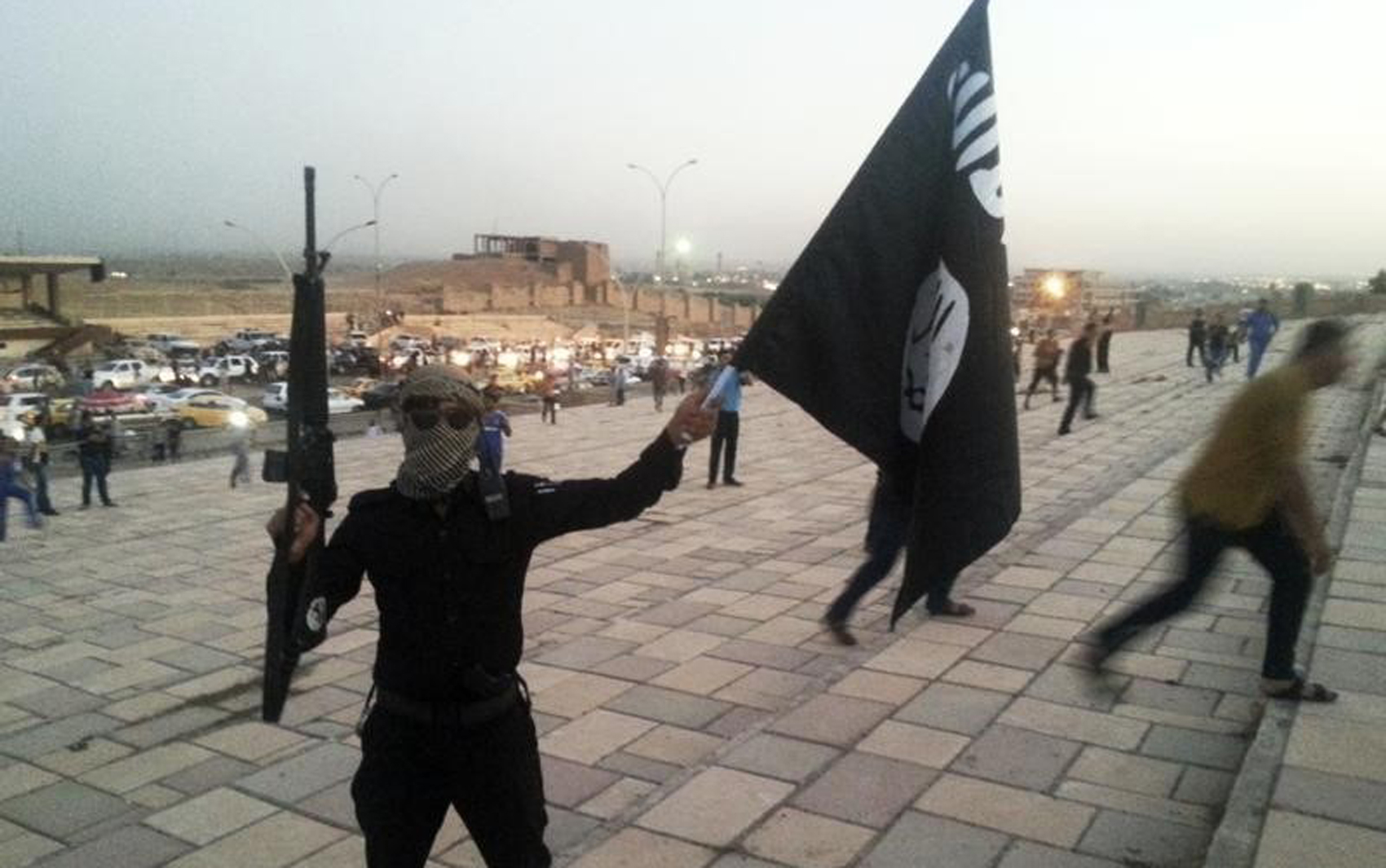 Imagem de arquivo mostra militante segurando arma e bandeira do Estado Islâmico em Mosul (Foto: Reuters)